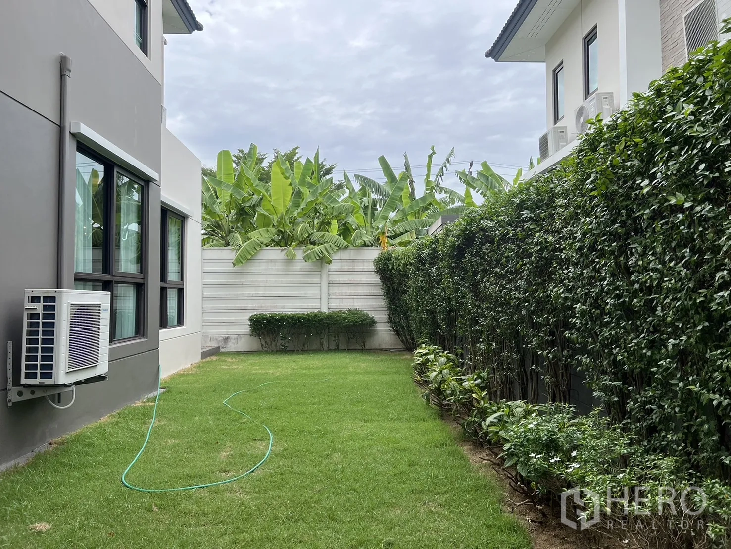 Detached House for rent or sale in Prawet, Bangkok - Private garden bordered by hedge and banana trees.