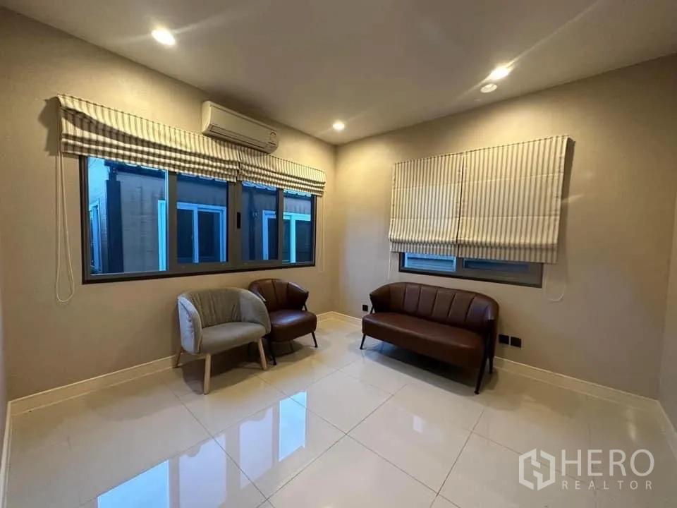 Detached House for rent in Bang Kapi, Bangkok - Cozy sitting room with tiled floor, windows and wall-mounted air conditioning.