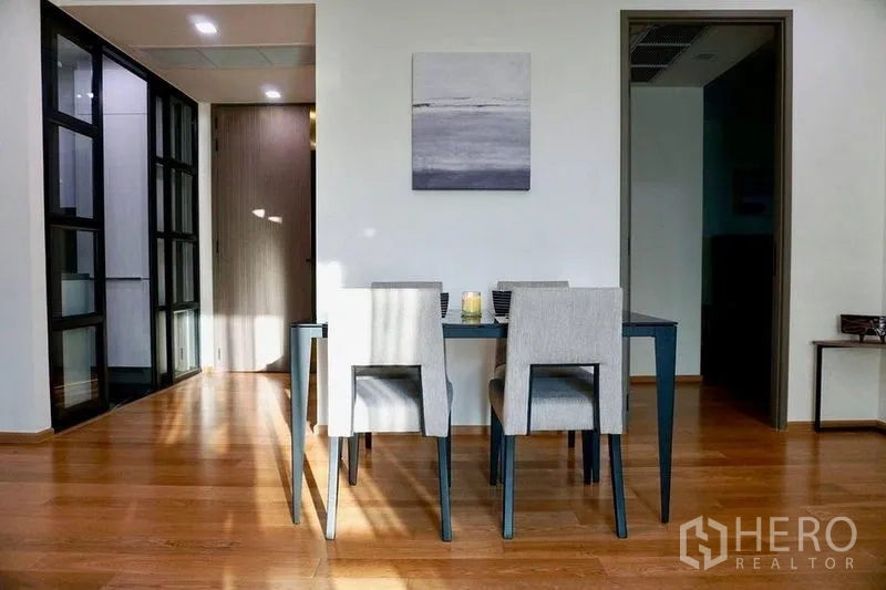 公寓 出租在Khlong Toei, Bangkok - 采光良好的用餐区，极简餐桌与软包椅