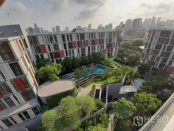 公寓 出租在Watthana, Bangkok - 俯瞰低层公寓围绕景观花园与泳池的庭院，远眺城市天际线