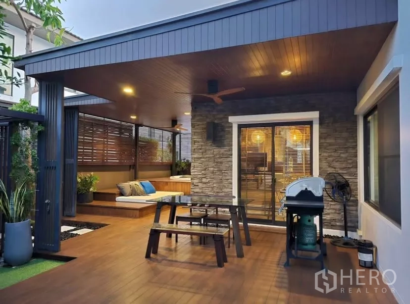 Detached House for rent in Bang Phli, Samut Prakan - Evening view of roofed patio with BBQ, dining set and warm lighting