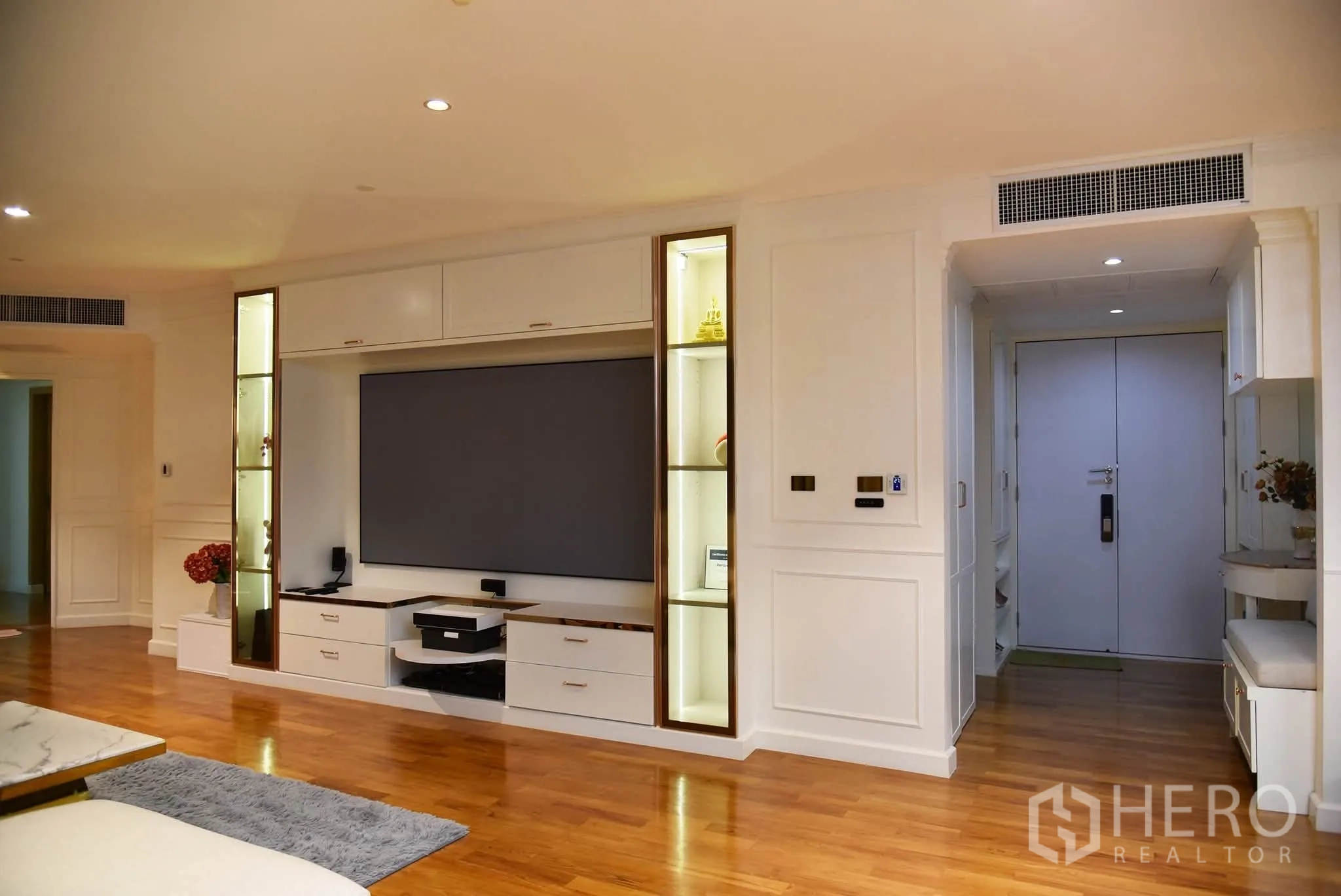 คอนโด for sale in Khlong San, Bangkok - ห้องนั่งเล่นพร้อมผนังทีวีบิวท์อิน ชั้นโชว์ และพื้นไม้โทนอุ่นใกล้ทางเข้า