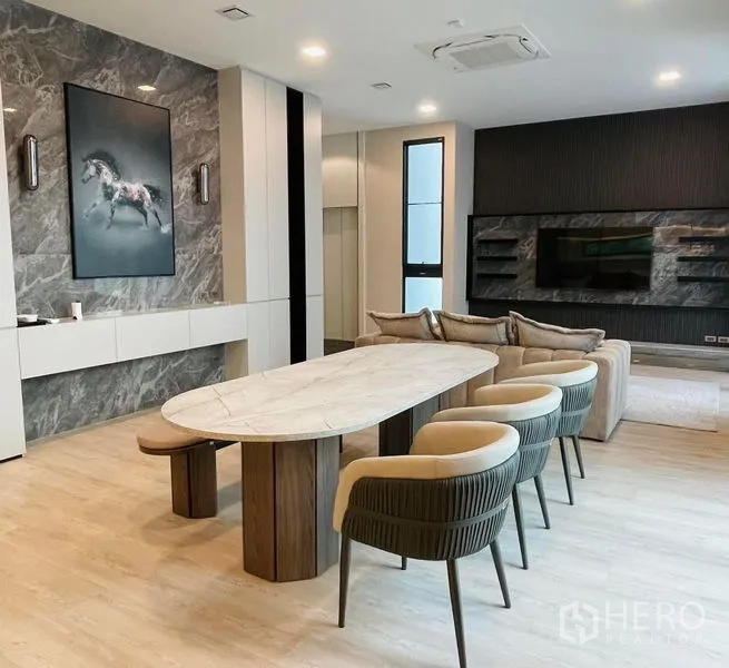 Detached House for rent - Dining room with oval marble table, upholstered chairs and adjacent media wall.