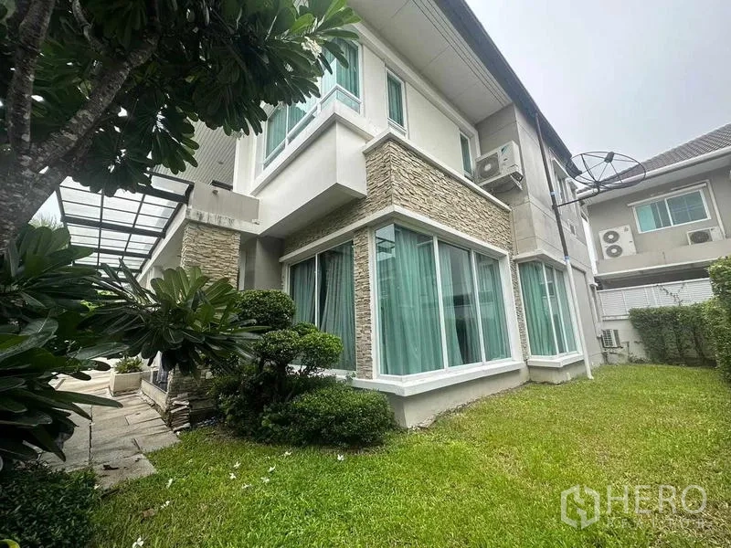 独立式住宅 出售在Saphan Sung, Bangkok - 房屋转角大面积落地窗，私家草坪与绿植。