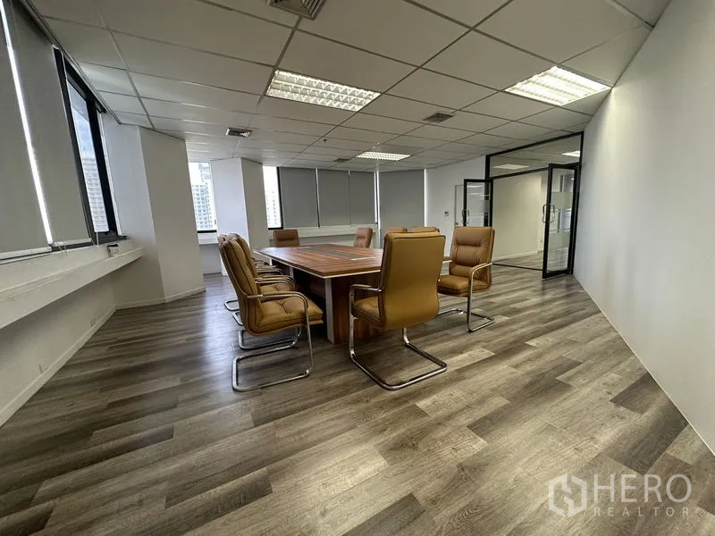 Office Space for rent or sale in Din Daeng, Bangkok - Meeting room with square conference table, tan chairs and modern flooring.