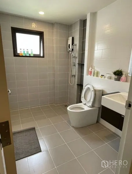 Detached House for rent - Modern bathroom with gray tiles, walk-in shower, toilet, and vanity with mirror.