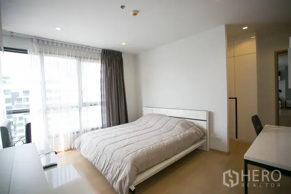 公寓 出租在Watthana, Bangkok - 采光充足的卧室，落地大窗、纱帘、书桌与大床。