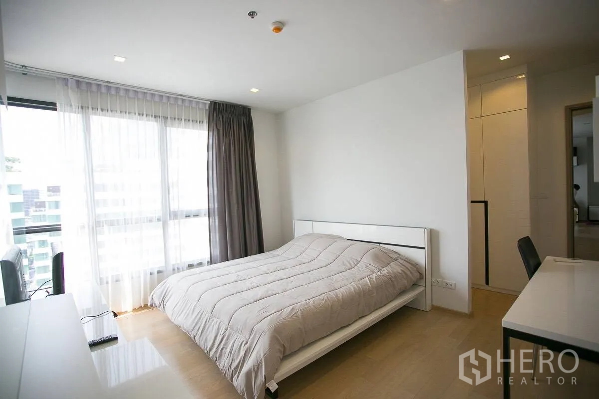 公寓 出租在Watthana, Bangkok - 采光充足的卧室，落地大窗、纱帘、书桌与大床。