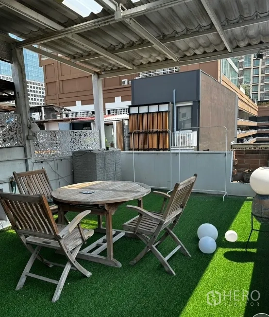 联排别墅 for rent in Sathon, Bangkok - 屋顶露台铺人造草地，圆桌座椅与城市景观。