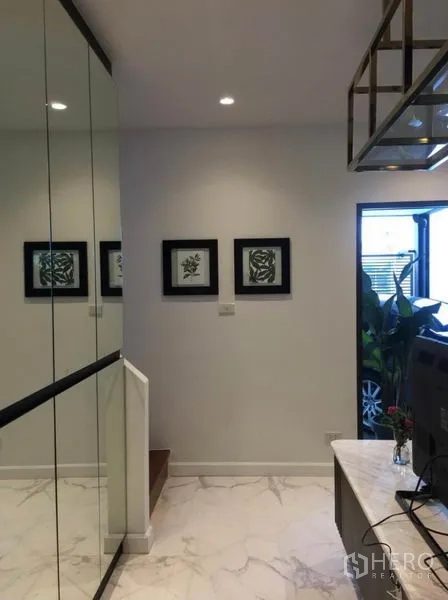联排别墅 出租在Khlong Toei, Bangkok - 入口走廊，镜面柜体、装饰画与通往二楼的楼梯