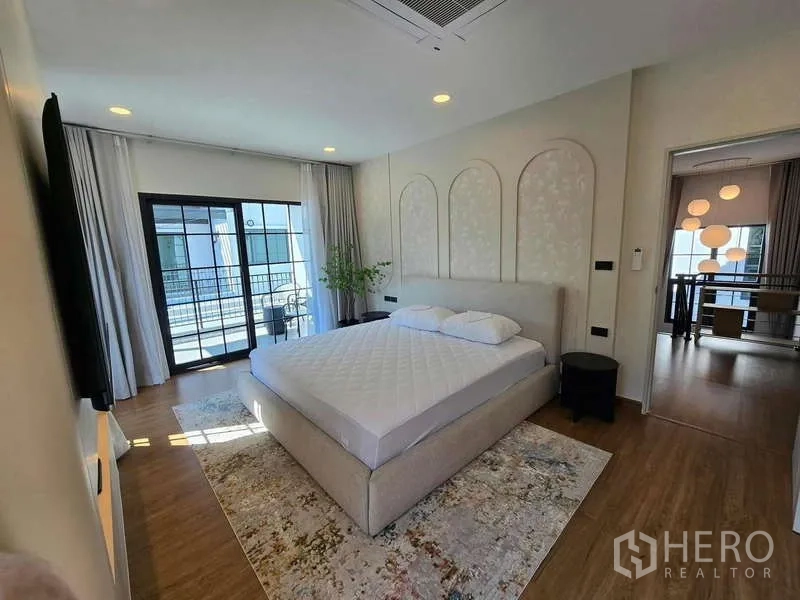 独立式住宅 出租在Bang Phli, Samut Prakan - 采光充足的主卧，特大床，木地板，推拉门通往阳台。