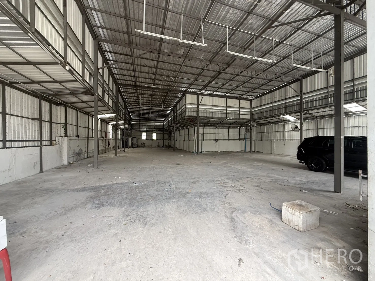 โกดัง for rent in Huai Khwang, Bangkok - ภายในโกดังพื้นที่โล่งเพดานสูง พื้นคอนกรีต มีชั้นลอยด้านข้างและพัดลมติดผนัง