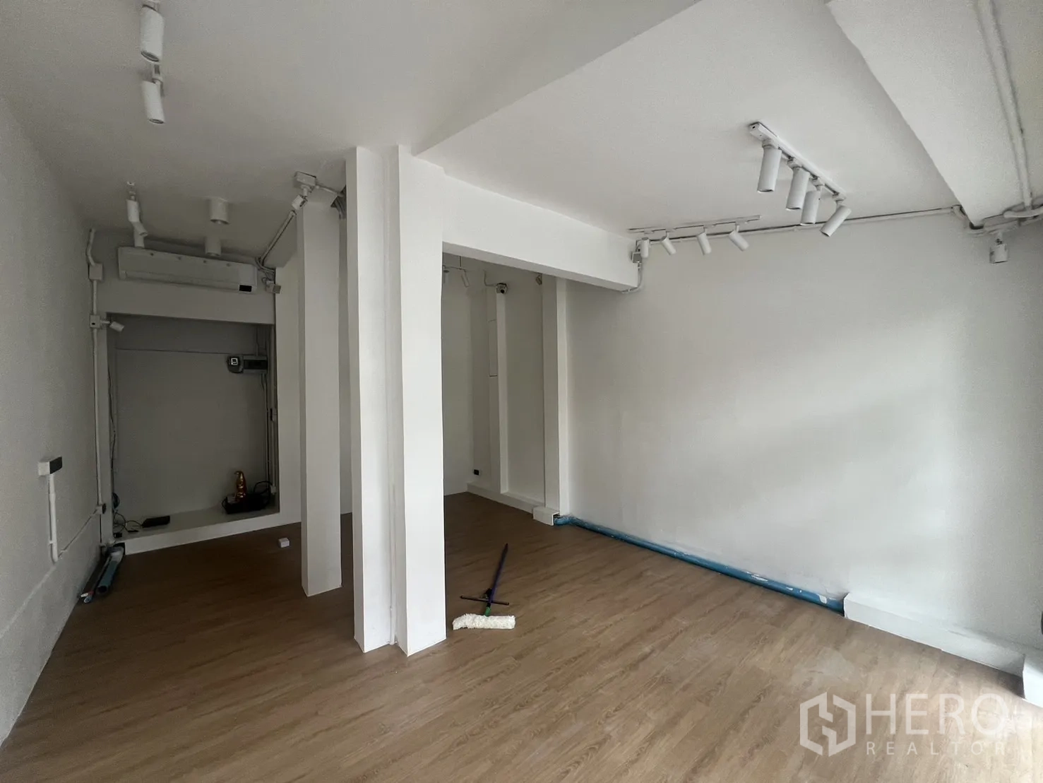 Retail Space for rent in Watthana, Bangkok - Open-plan retail interior with white walls, wood-look flooring, structural columns and bright track lighting.