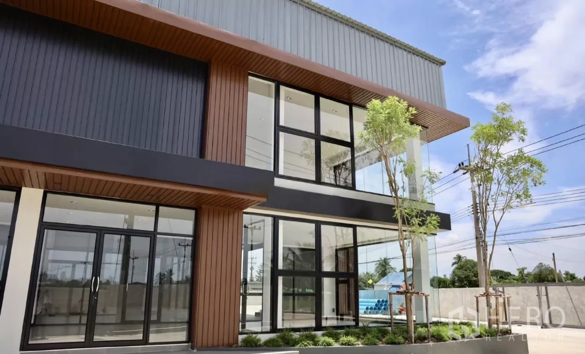 Factory for rent or sale in Phutthamonthon, Nakhon Pathom - Ground-level office entrance with floor-to-ceiling windows and shaded canopy.
