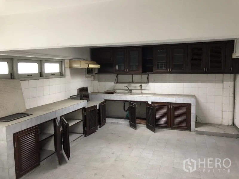 Office Space for rent in Huai Khwang, Bangkok - Pantry with tiled backsplash, long counters and dark wood cabinets.