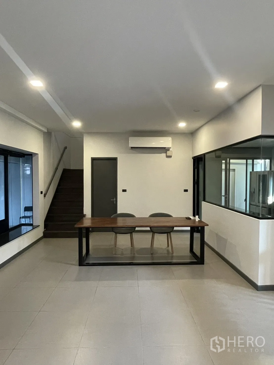 Townhouse for sale in Bang Phli, Samut Prakan - Open-plan ground floor with dining table, air conditioner, and staircase.
