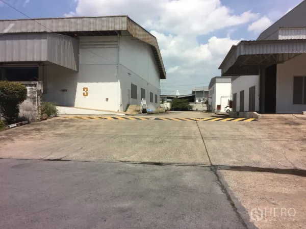 货栈 出租在Khlong Luang, Pathum Thani - 两栋仓库之间的内部道路，带上坡道、减速带和装卸入口。