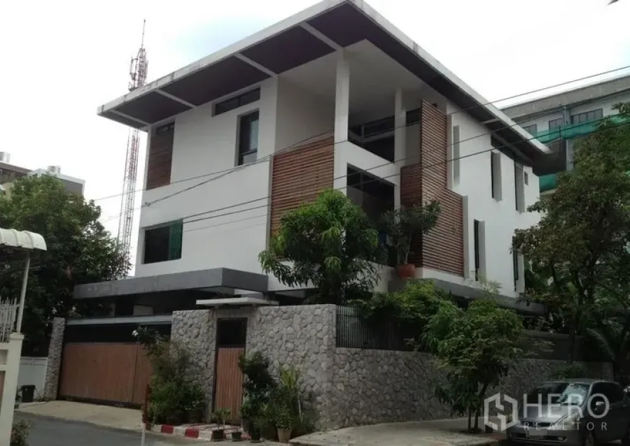 Home Office for rent or sale in Bang Rak, Bangkok - Street-side view of the contemporary home office facade behind a high stone fence.