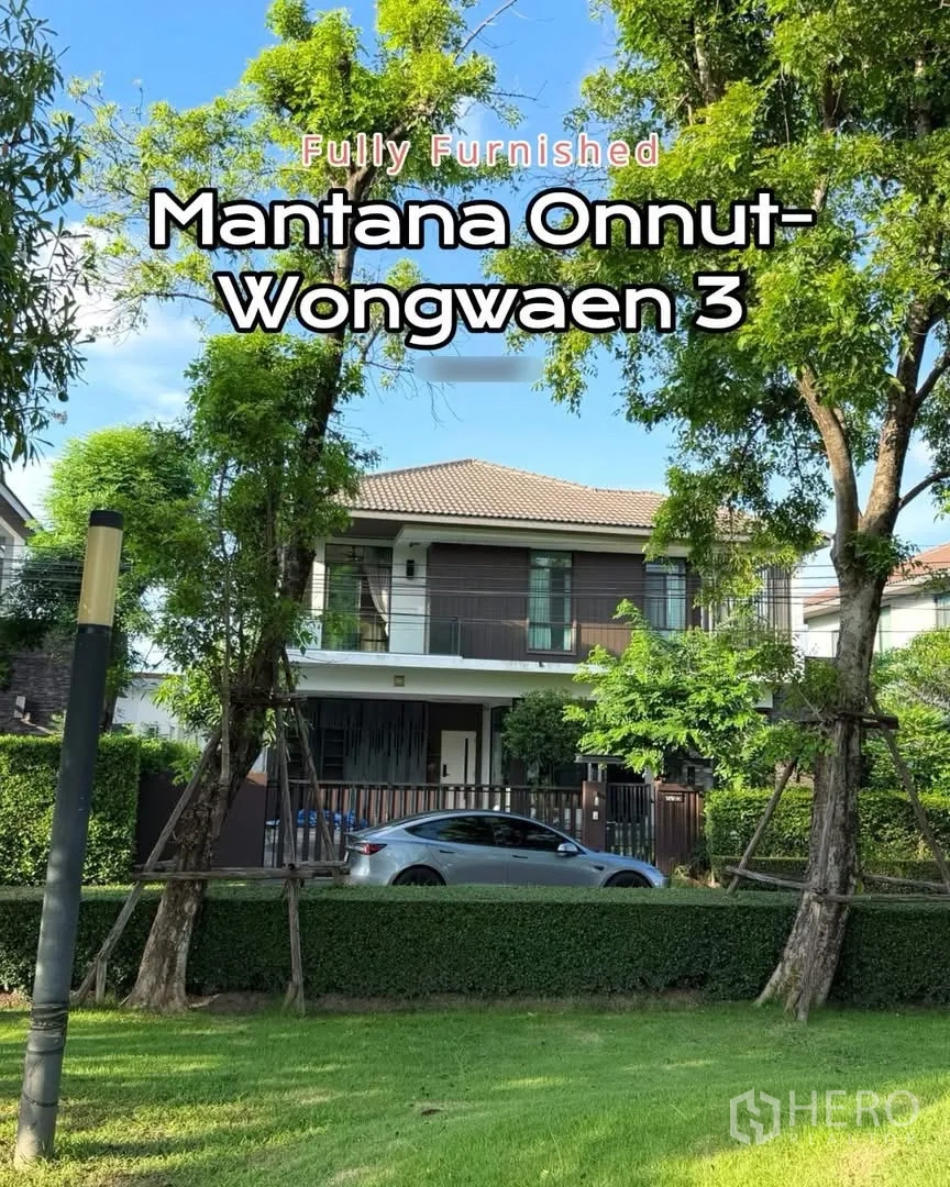 Detached House for rent in Prawet, Bangkok - Two-storey detached house with an upper balcony and landscaped front yard behind a fence.