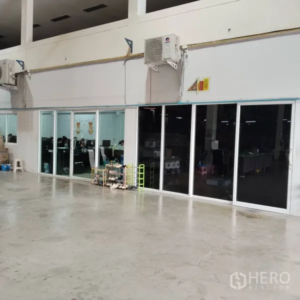 Warehouse for rent in Bang Khun Thian, Bangkok - Glass-walled office rooms inside the warehouse with concrete floor.