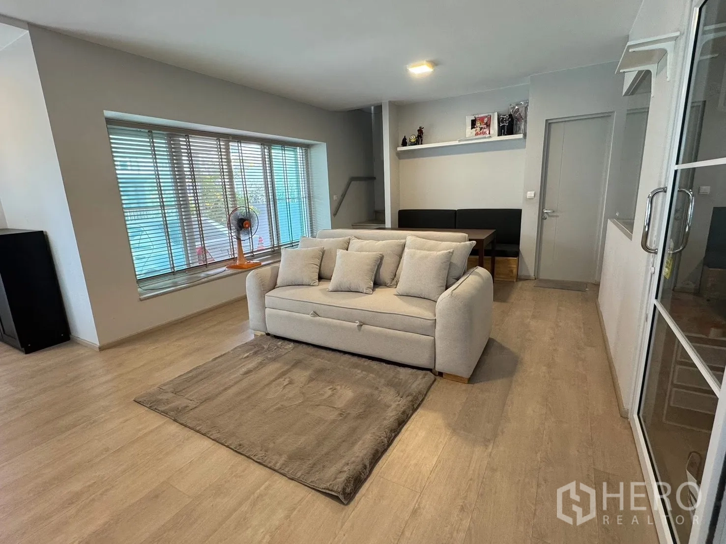 半独立式住宅 for rent in Prawet, Bangkok - 采光充足的客厅，设宽大飘窗、沙发与木纹地板。