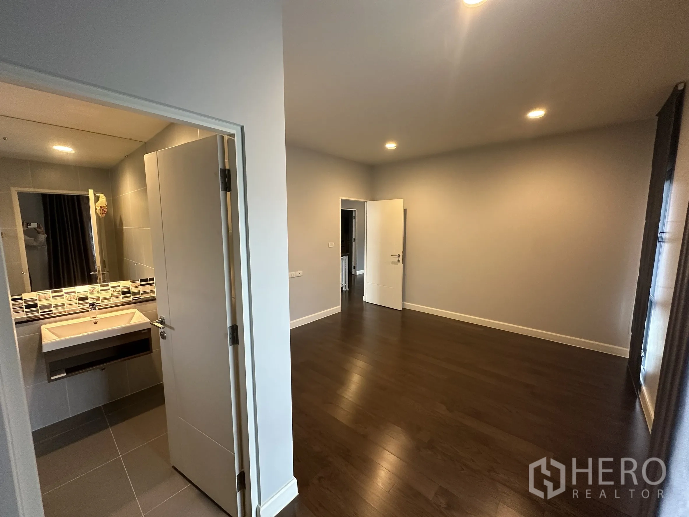 Detached House for rent in Lam Luk Ka, Pathum Thani - Large bedroom with ensuite door and recessed lighting.