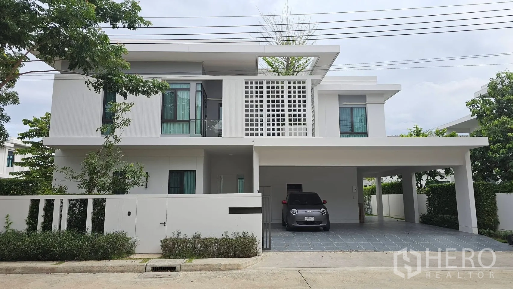 独栋房屋 for rent in Bang Phli, Samut Prakan - 房屋正立面，带宽阔有顶车棚与格栅阳台及车道。
