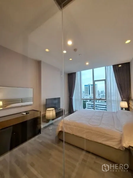 Condominium for rent in Bang Rak, Bangkok - Bright bedroom with floor-to-ceiling windows, city view, and glass wall.