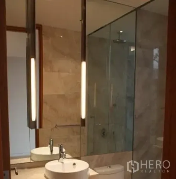 Condominium for sale in Sathon, Bangkok - Contemporary bathroom with glass-enclosed shower, vanity and tall mirror in the condo.