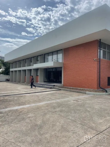 Factory for rent in Mueang Samut Prakan, Samut Prakan - Two-storey red-brick industrial building with ample parking apron