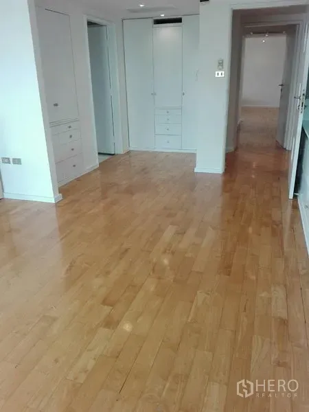 Condominium for rent in Khlong Toei, Bangkok - Hallway area with built-in wardrobes and polished wooden flooring leading to bedrooms.