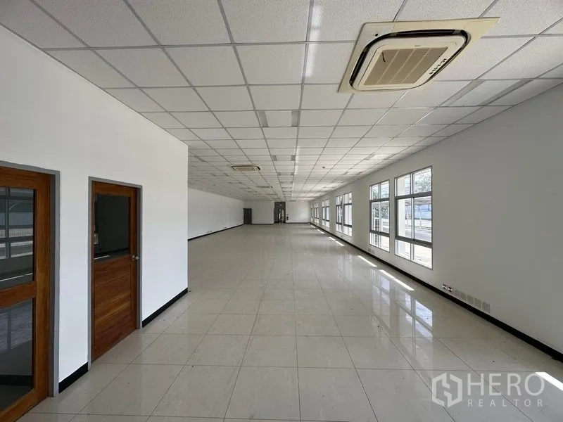 Factory for rent in Bang Sao Thong, Samut Prakan - Long corridor-style office area with ceiling cassette AC units and multiple windows.
