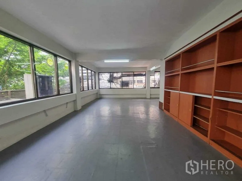 零售空间 出租在Bang Rak, Bangkok - 楼层工作区，环窗视野与内建置物柜，可见绿树。