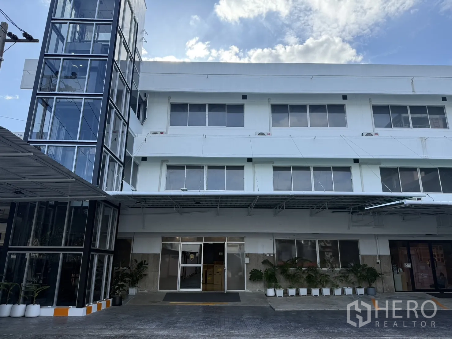 办公空间 出租在Wang Thonglang, Bangkok - 三层办公楼正立面，带玻璃私家电梯与车道。