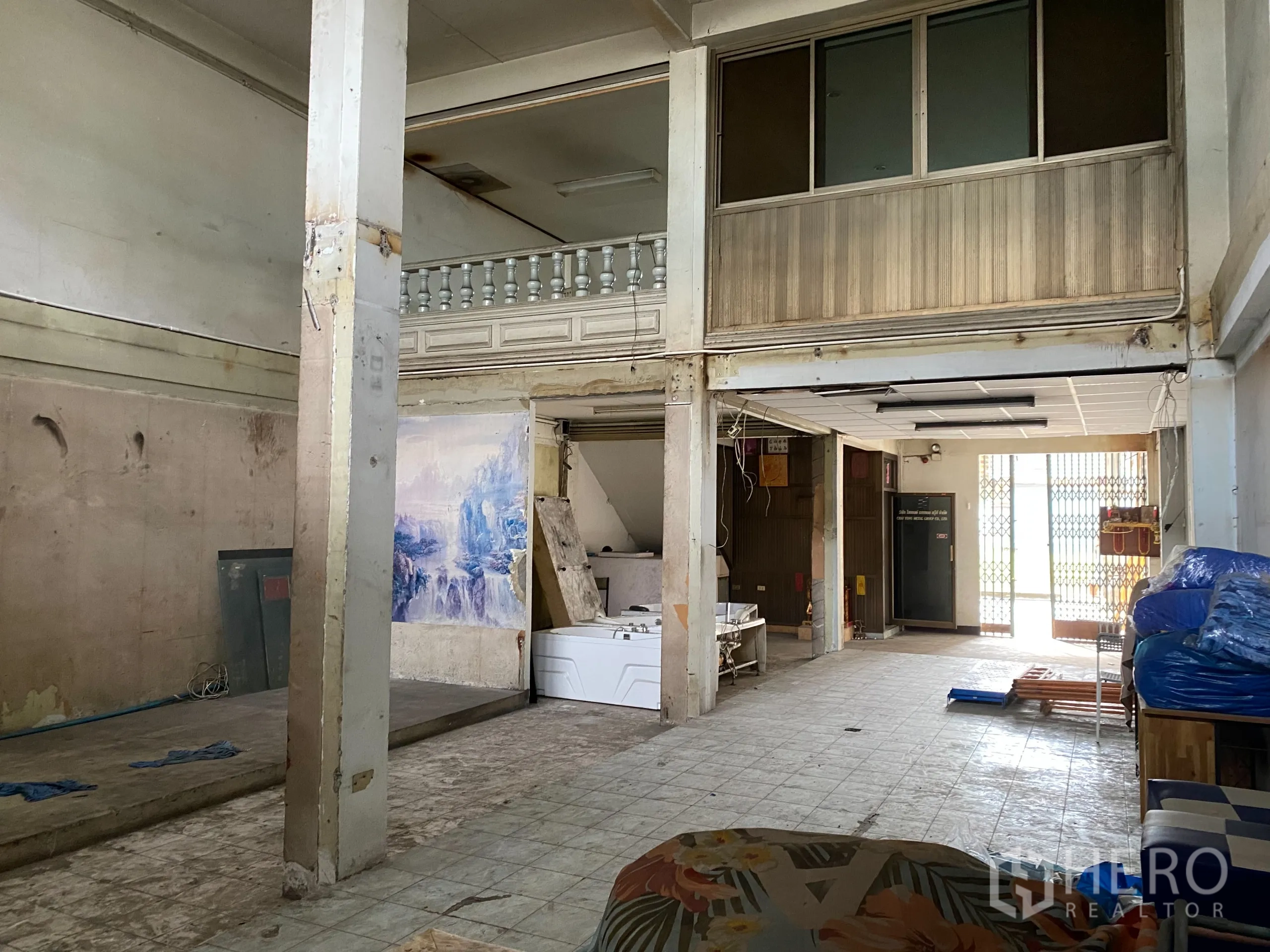 Retail Space for rent in Yan Nawa, Bangkok - Ground-floor retail hall with pillars, mezzanine and front folding security gate.
