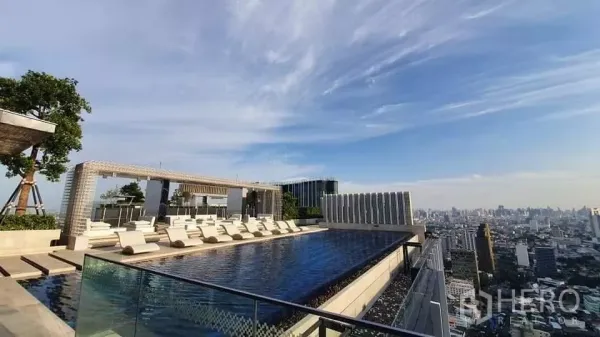 Condominium for rent in Chatuchak, Bangkok - Rooftop infinity swimming pool with sun loungers and city views.