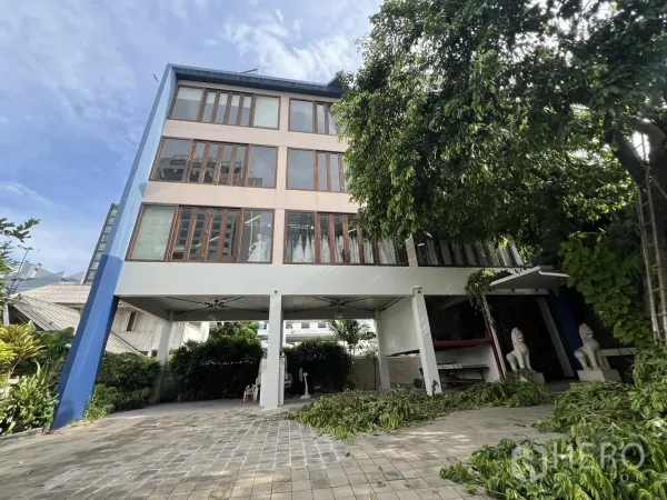 带办公室的家 出租在Watthana, Bangkok - 四层Home Office外观，架空停车区、大面积木框窗，绿树环绕。