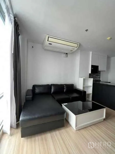 คอนโด ให้เช่าในSathon, Bangkok - มุมนั่งเล่นโซฟาหนังดำข้างหน้าต่างบานใหญ่