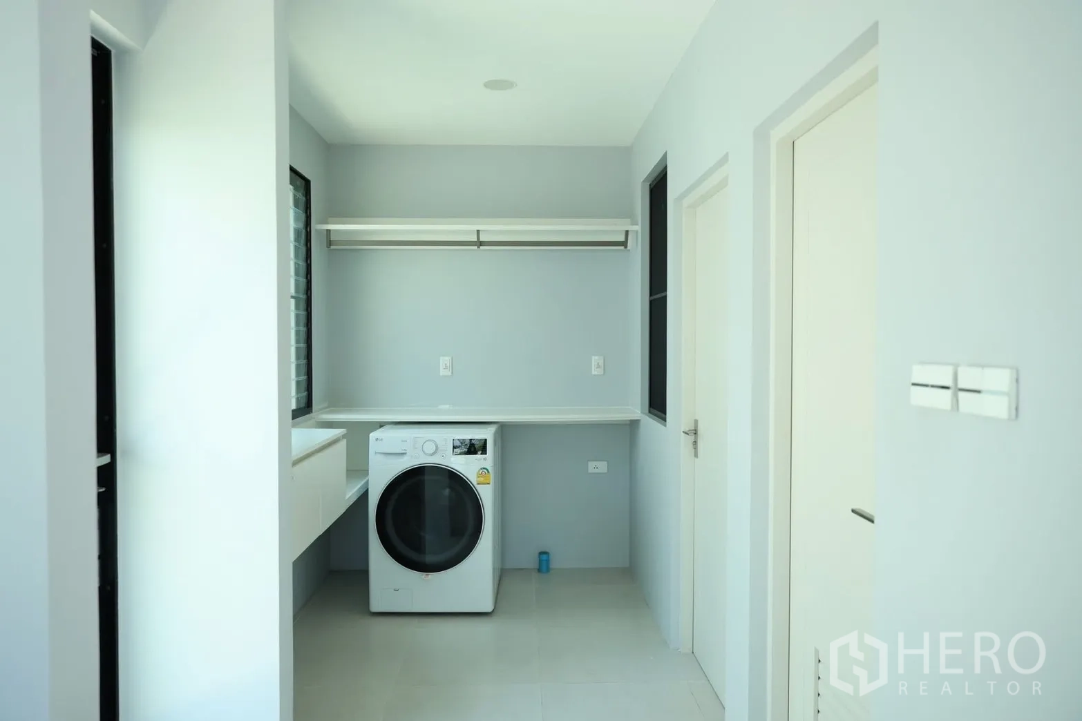 Detached House for rent or sale in Saphan Sung, Bangkok - Laundry room with washing machine, countertop workspace, and storage.