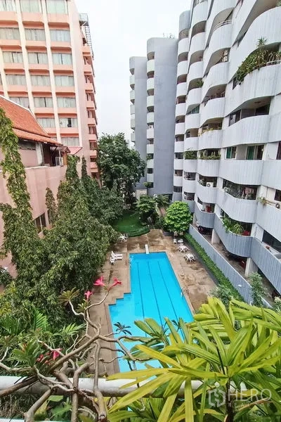 คอนโด ขายในBangkok - วิวสระว่ายน้ำส่วนกลางท่ามกลางอาคารพักอาศัยและต้นไม้เขียว