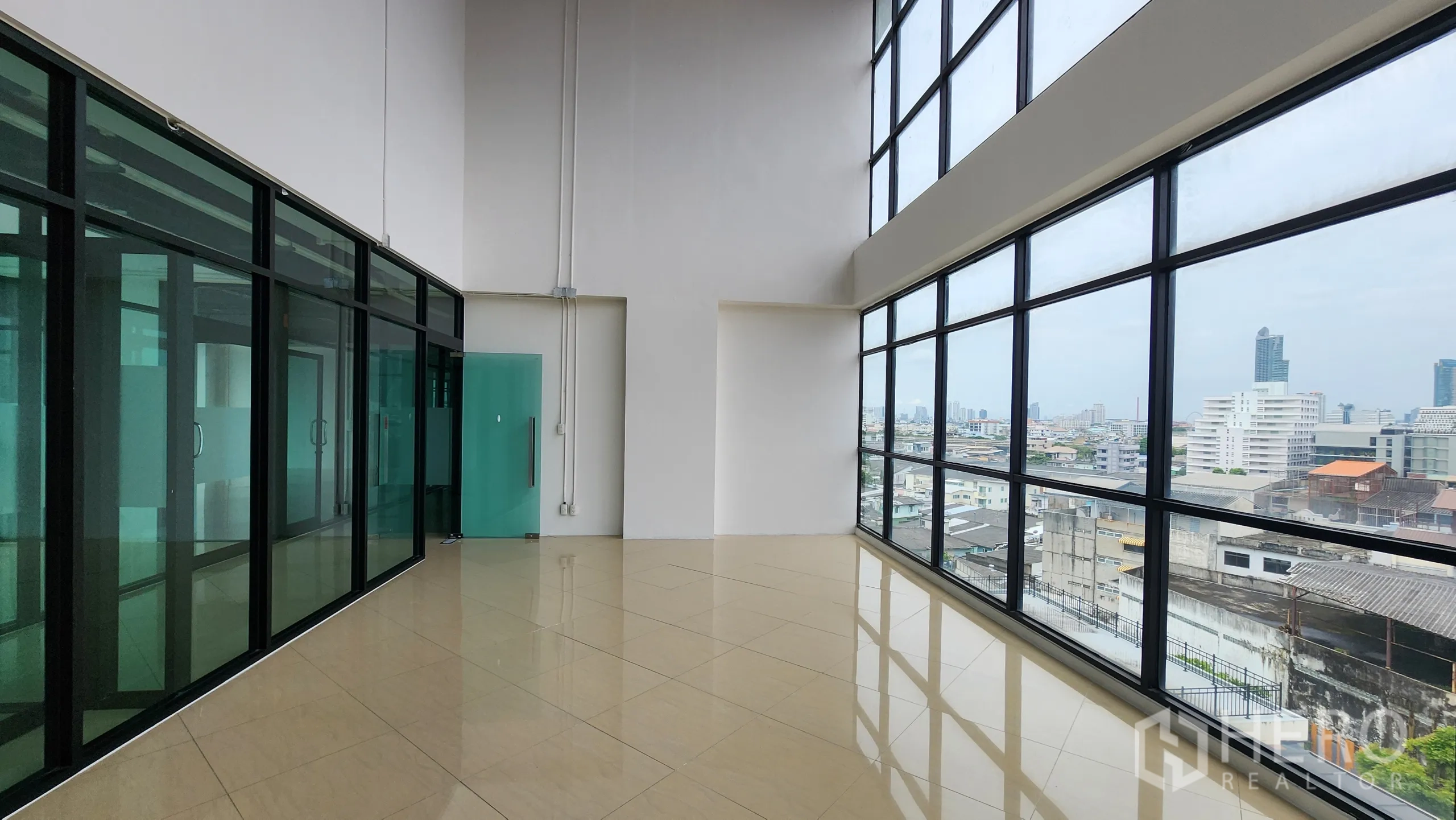 办公空间 出租在Yan Nawa, Bangkok - 玻璃长廊望城景，配青绿色门通向办公室。