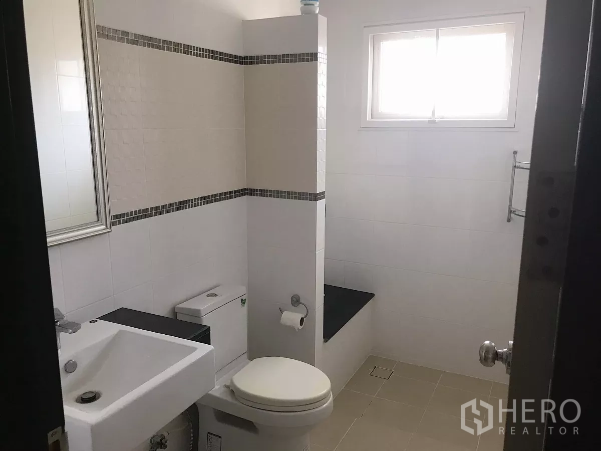 Detached House for sale in Lat Krabang, Bangkok - White-tiled bathroom with walk-in shower, vanity and toilet.