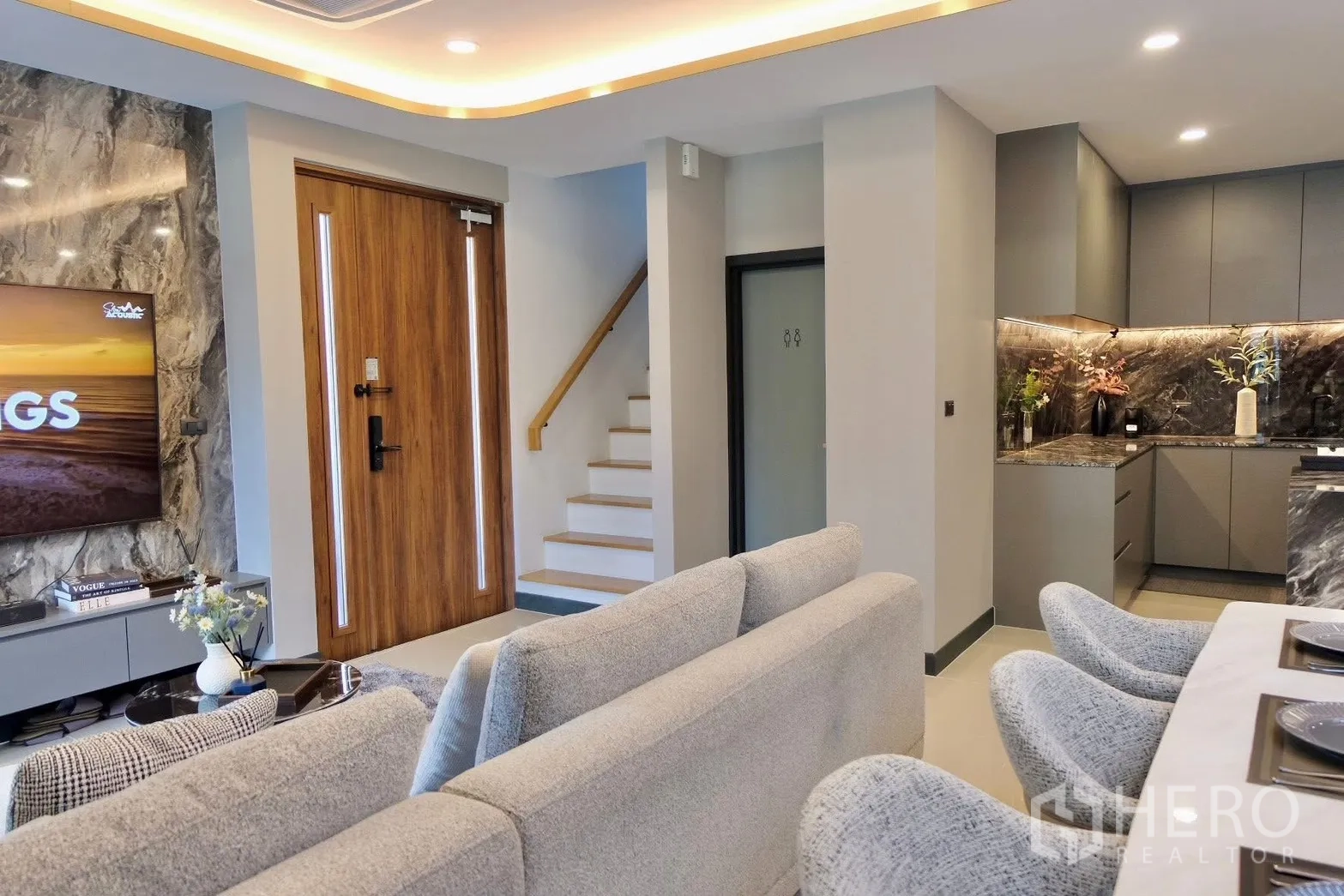 半独立式住宅 for sale in Prawet, Bangkok - 电视背景墙铺石纹装饰，对面为入户门。