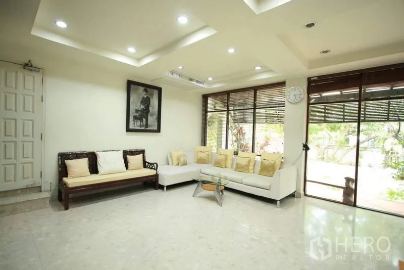 独立式住宅 出租在Bang Phli, Samut Prakan - 现代客厅，吊顶筒灯，白色转角沙发，大窗景观绿意。