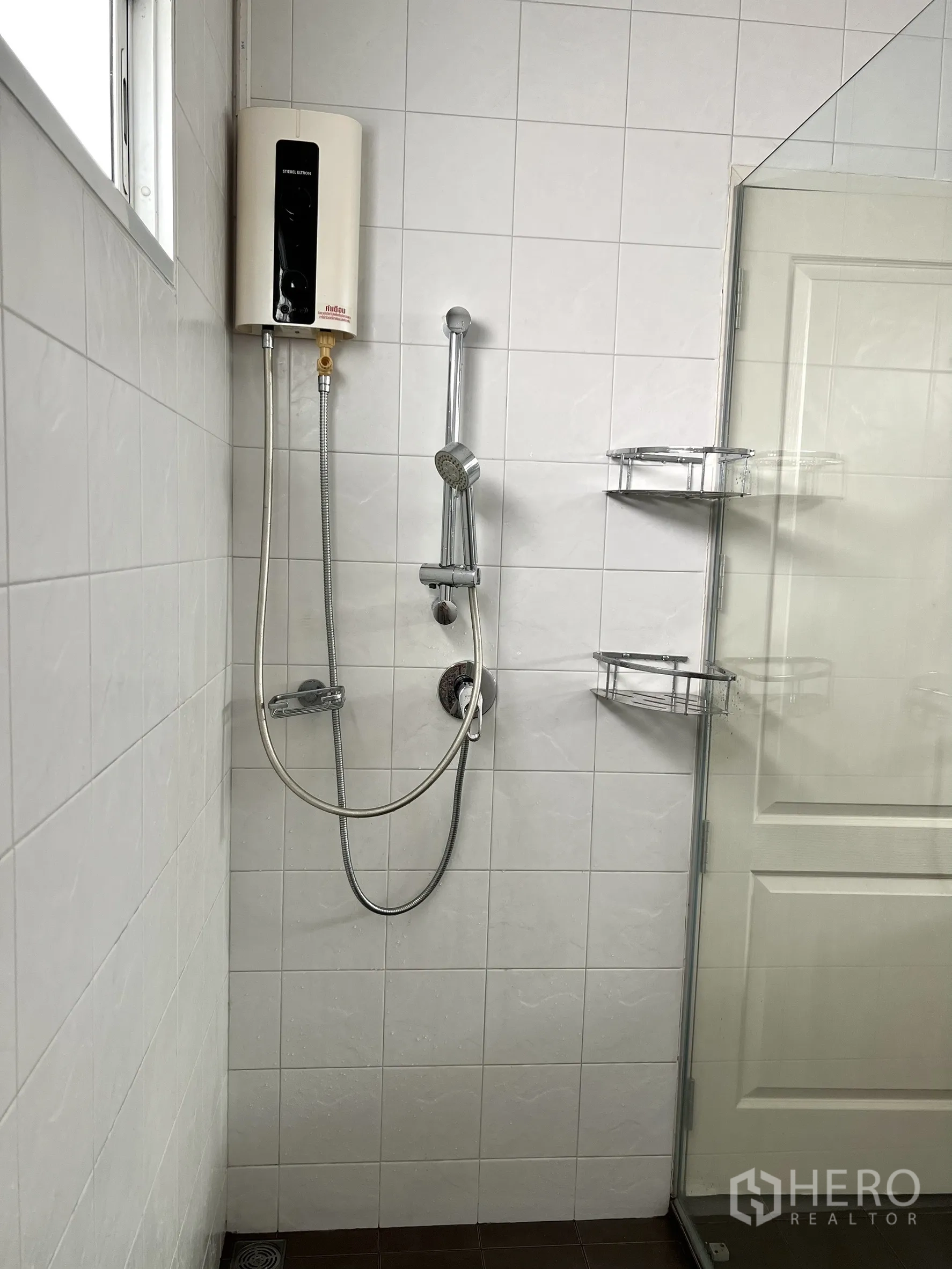 独立式住宅 出租或出售在Saphan Sung, Bangkok - 淋浴区带热水器与手持花洒，墙面瓷砖。