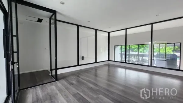 Home Office for rent - Open office room with black-framed glass partitions and dark wood floors.