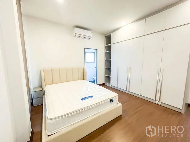 Detached House for rent in Bang Phli, Samut Prakan - Bedroom with wall-to-wall closets, open shelving, AC and door to bathroom.