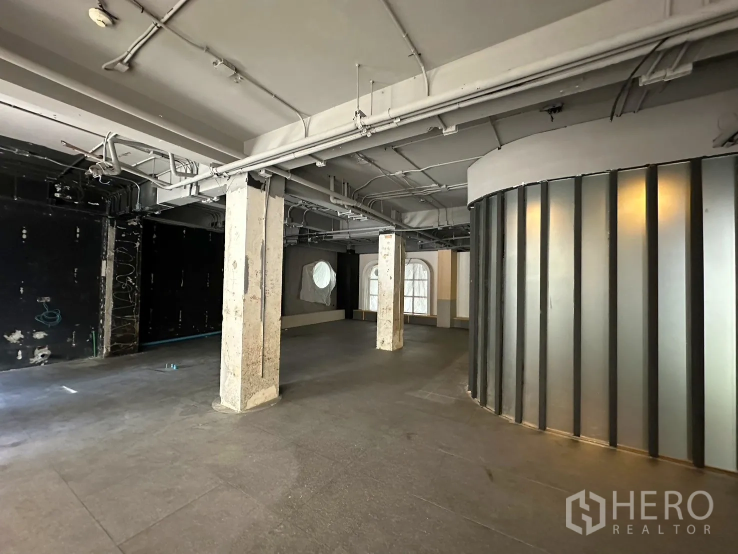 พื้นที่ขายของ for rent in Watthana, Bangkok - พื้นที่เชลล์แสดงผนังกั้นโค้งแบบฝ้าโปร่ง เพดานงานระบบ และพื้นโล่งกว้าง.