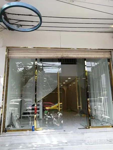 店屋 出租在Watthana, Bangkok - 临街玻璃门面商铺，金色边框与卷闸门，位于通罗区域。