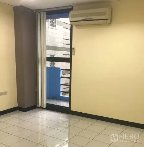 Office Space for rent in Bang Rak, Bangkok - Private office area with wall-mounted air conditioner and glass door opening to a small balcony.